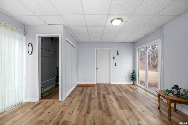 interior space with a paneled ceiling and light wood-type flooring