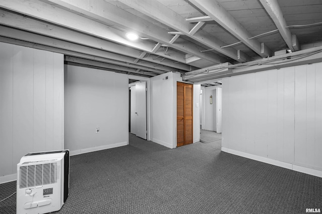 basement with heating unit and dark carpet