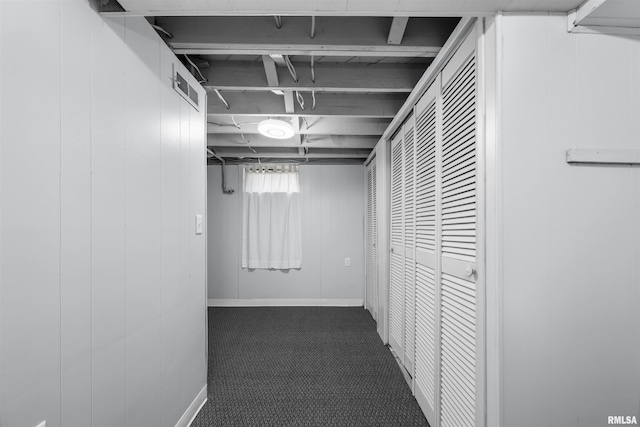 hall with dark colored carpet