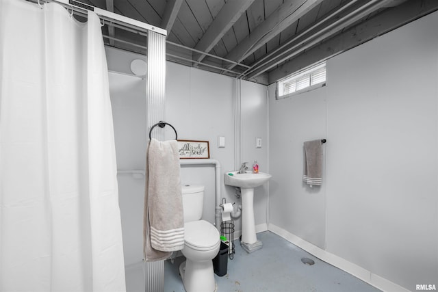 bathroom featuring toilet, concrete flooring, and sink