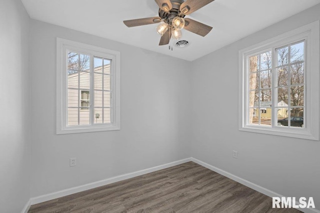 spare room with ceiling fan and dark hardwood / wood-style flooring