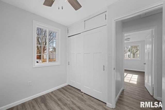 unfurnished bedroom featuring ceiling fan, light wood-type flooring, and a closet