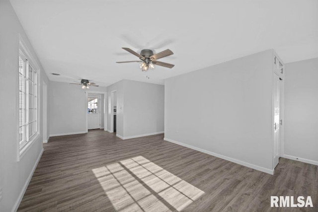 unfurnished living room featuring dark wood-type flooring and ceiling fan