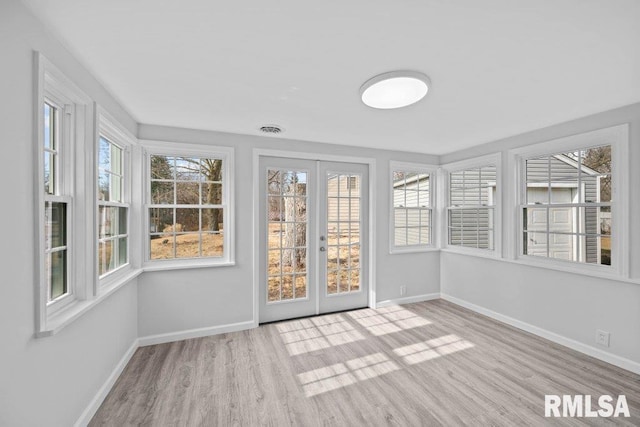 unfurnished sunroom with a wealth of natural light and french doors