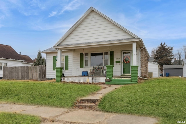 bungalow-style home with covered porch and a front lawn