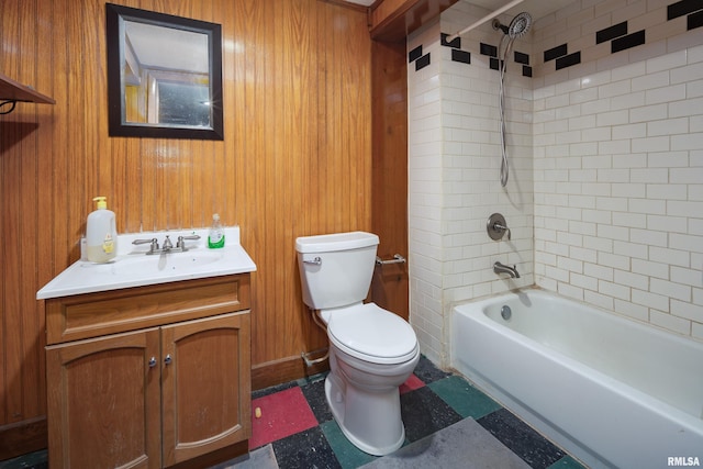 full bathroom with tiled shower / bath combo, vanity, wooden walls, and toilet