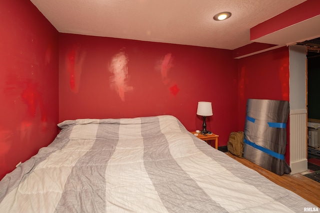 bedroom featuring hardwood / wood-style flooring and a textured ceiling