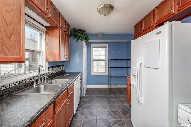 kitchen with white appliances, sink, and backsplash