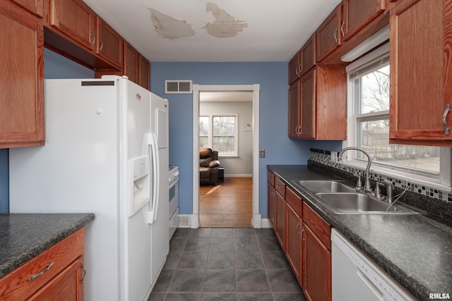 kitchen with white appliances, plenty of natural light, sink, and decorative backsplash