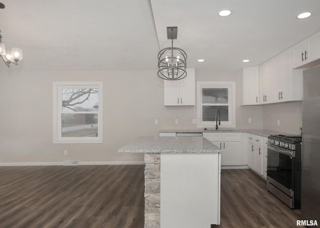 kitchen featuring decorative light fixtures, white cabinets, and appliances with stainless steel finishes