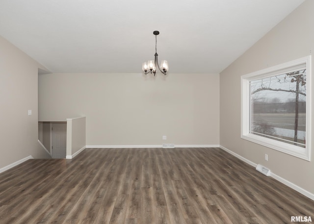 spare room with an inviting chandelier, vaulted ceiling, and dark hardwood / wood-style floors