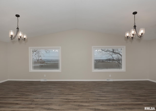 empty room featuring vaulted ceiling, dark hardwood / wood-style floors, and a chandelier