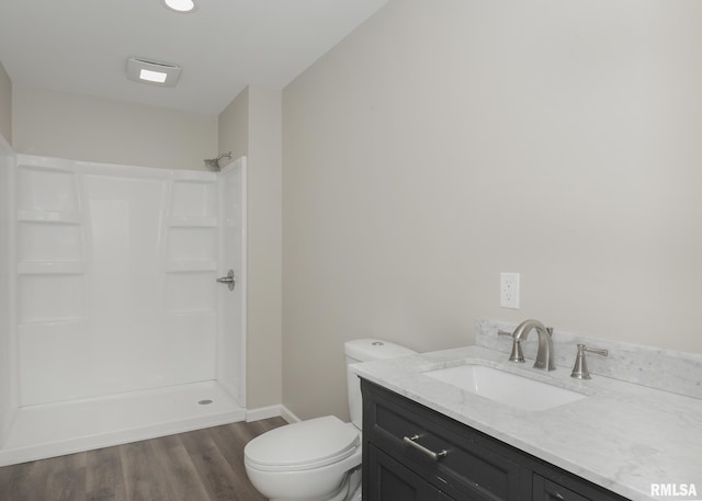 bathroom with vanity, wood-type flooring, a shower, and toilet