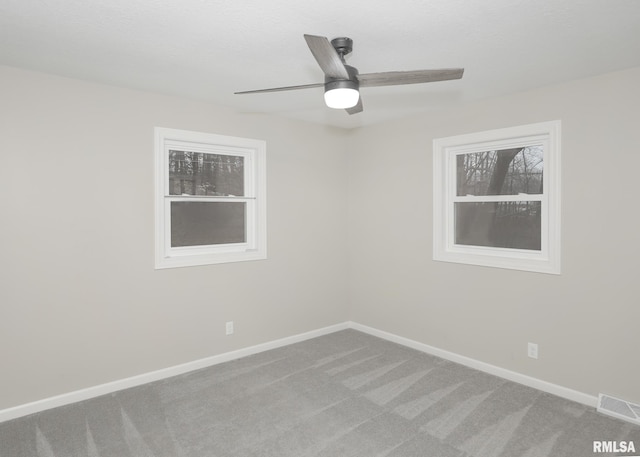 carpeted spare room with ceiling fan