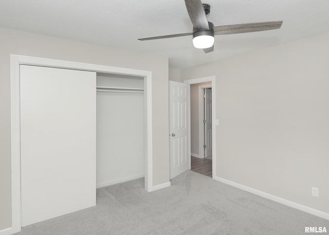 unfurnished bedroom with ceiling fan, light colored carpet, a closet, and a textured ceiling