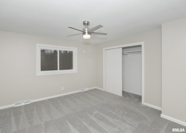 unfurnished bedroom featuring light colored carpet, a textured ceiling, ceiling fan, and a closet