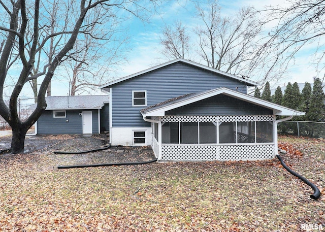 rear view of property featuring a sunroom