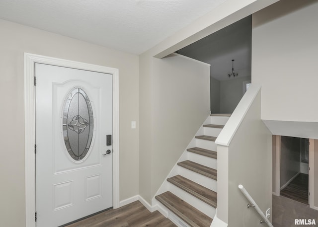 foyer entrance with hardwood / wood-style flooring and a textured ceiling