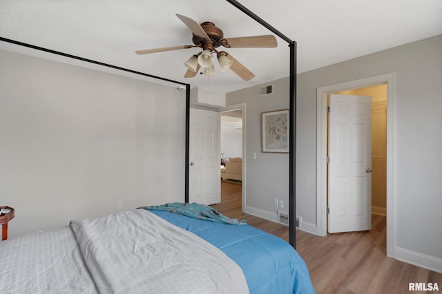 bedroom featuring ceiling fan, light hardwood / wood-style floors, and a textured ceiling