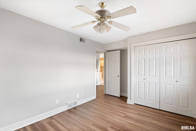 unfurnished bedroom with light hardwood / wood-style floors, a closet, and ceiling fan