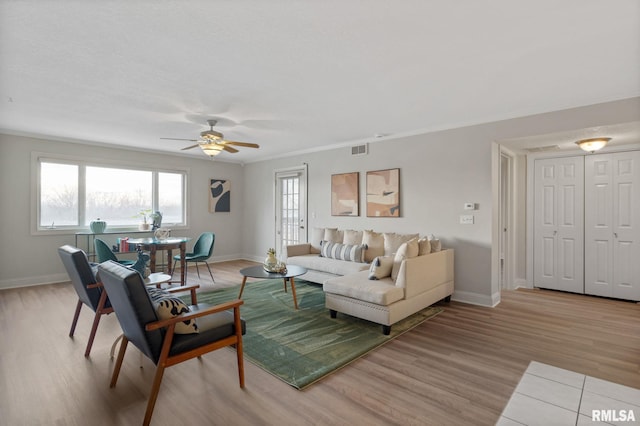 living room with ceiling fan, ornamental molding, and light hardwood / wood-style floors