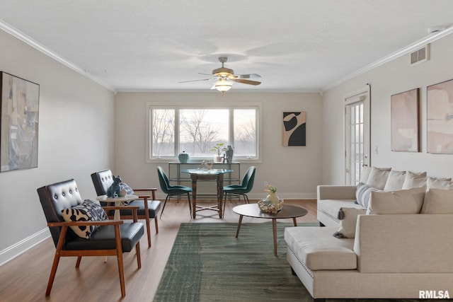 living room with hardwood / wood-style flooring, crown molding, and ceiling fan