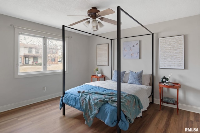 bedroom featuring ceiling fan, hardwood / wood-style floors, and a textured ceiling