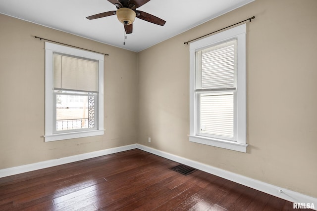 empty room with dark hardwood / wood-style floors and ceiling fan