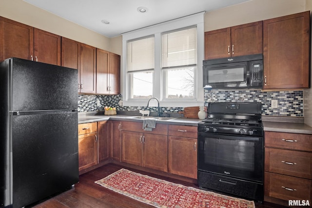 kitchen with sink, decorative backsplash, dark wood-type flooring, and black appliances