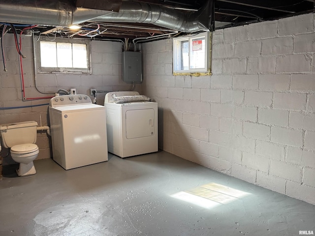 below grade area with plenty of natural light, electric panel, and washer and clothes dryer