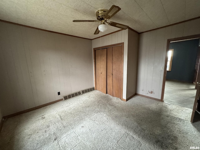 unfurnished bedroom with light colored carpet, ornamental molding, a closet, and ceiling fan