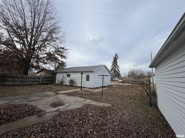 view of yard with an outbuilding, a garage, and a patio