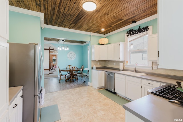 kitchen featuring stainless steel appliances, sink, white cabinets, and decorative light fixtures