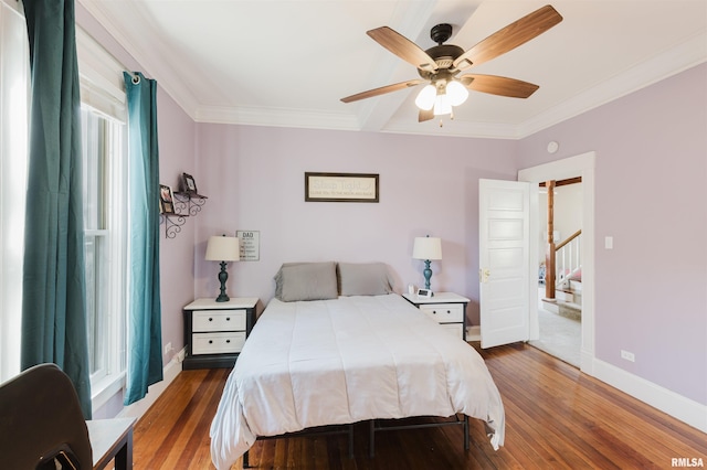 bedroom featuring hardwood / wood-style flooring, ornamental molding, and ceiling fan