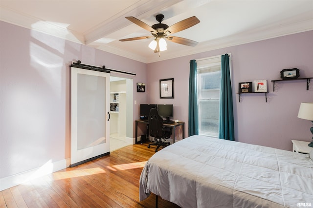 bedroom with crown molding, a barn door, ceiling fan, and light wood-type flooring