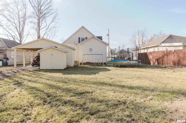 exterior space featuring a carport, a trampoline, and a shed