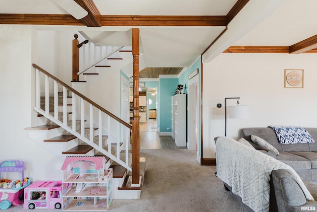 living room with crown molding, carpet, and beam ceiling