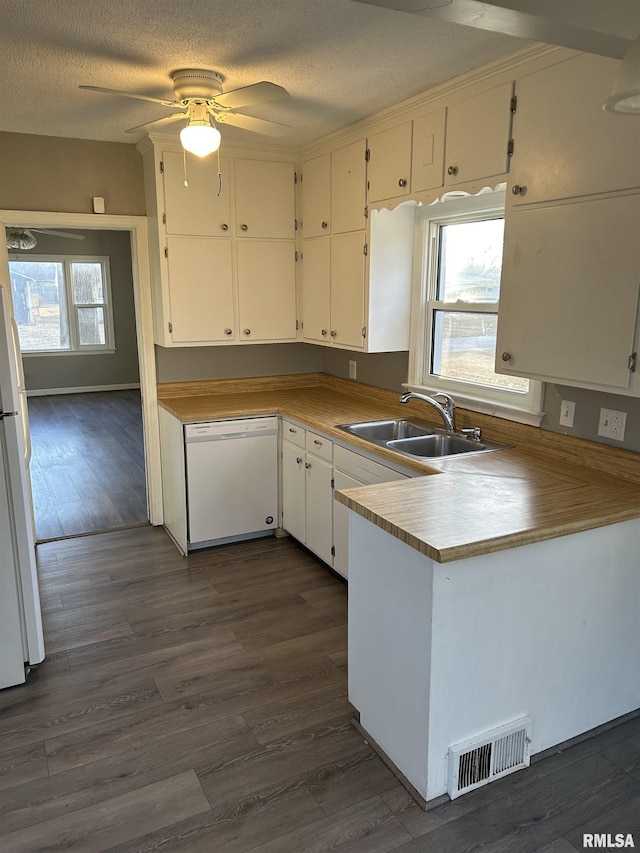 kitchen featuring dark wood-type flooring, sink, a textured ceiling, white appliances, and white cabinets