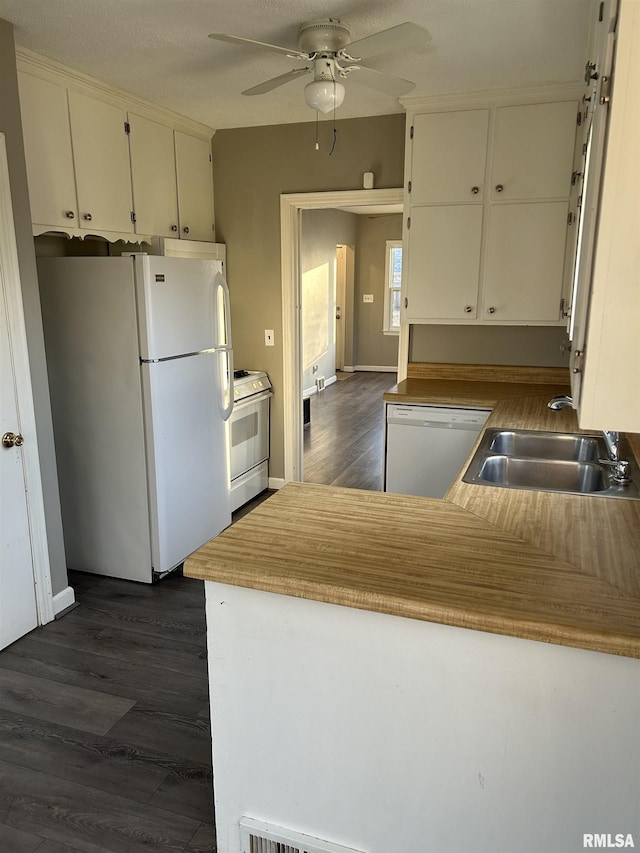 kitchen featuring sink, white appliances, dark wood-type flooring, white cabinetry, and kitchen peninsula