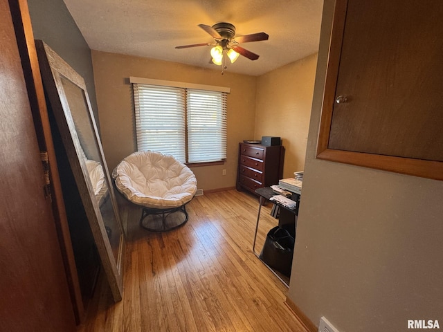 sitting room with ceiling fan and light hardwood / wood-style floors