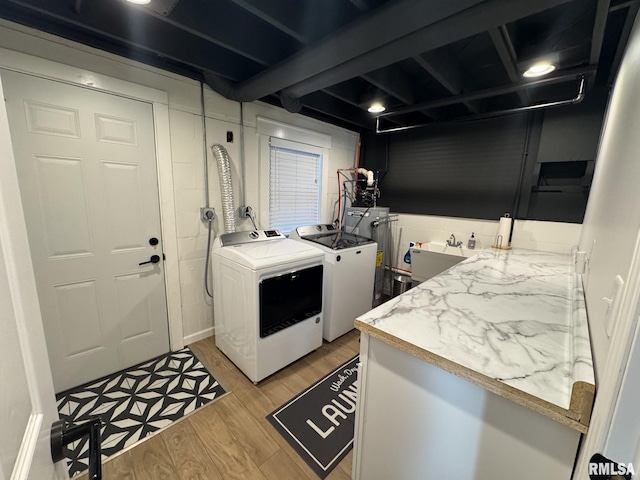 laundry room featuring sink, independent washer and dryer, and light hardwood / wood-style floors