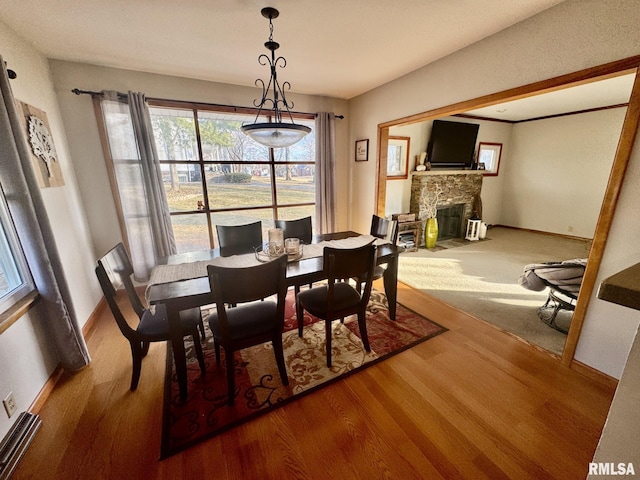 dining space with hardwood / wood-style floors and a fireplace