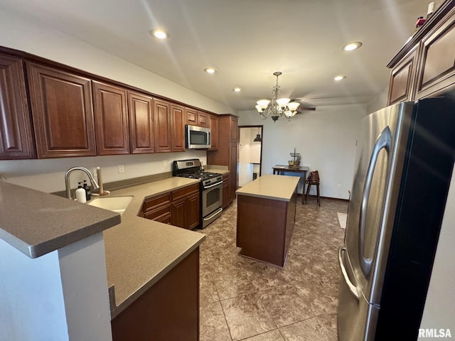 kitchen with appliances with stainless steel finishes, sink, a chandelier, a center island, and kitchen peninsula