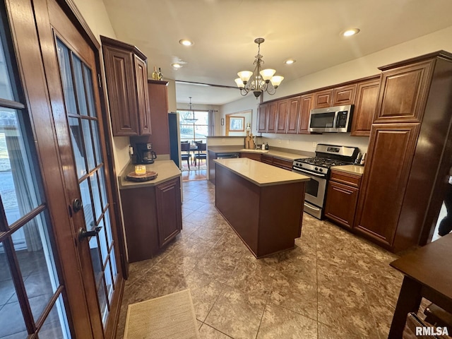 kitchen with a chandelier, hanging light fixtures, a center island, kitchen peninsula, and stainless steel appliances