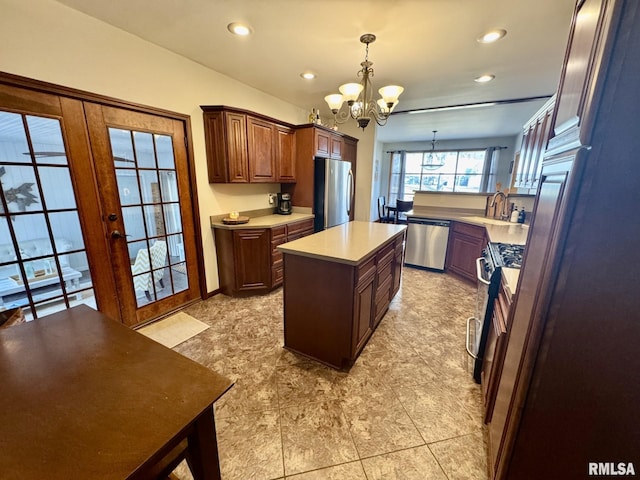 kitchen with a chandelier, hanging light fixtures, a center island, stainless steel appliances, and french doors