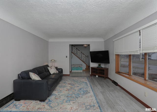 living room featuring light hardwood / wood-style flooring and a textured ceiling