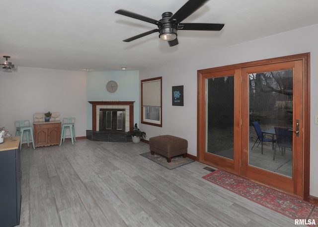 unfurnished living room featuring a fireplace, light hardwood / wood-style floors, and ceiling fan