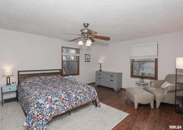 bedroom with dark wood-type flooring, ceiling fan, and a textured ceiling