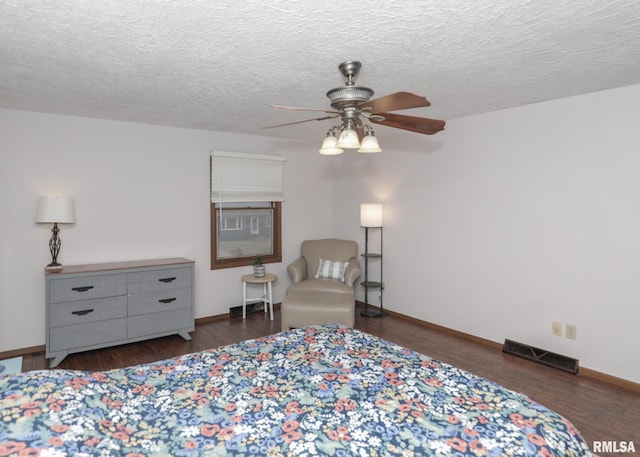 sitting room with dark hardwood / wood-style floors, a textured ceiling, and ceiling fan