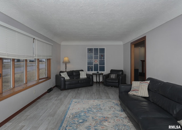 living room with light hardwood / wood-style flooring and a textured ceiling